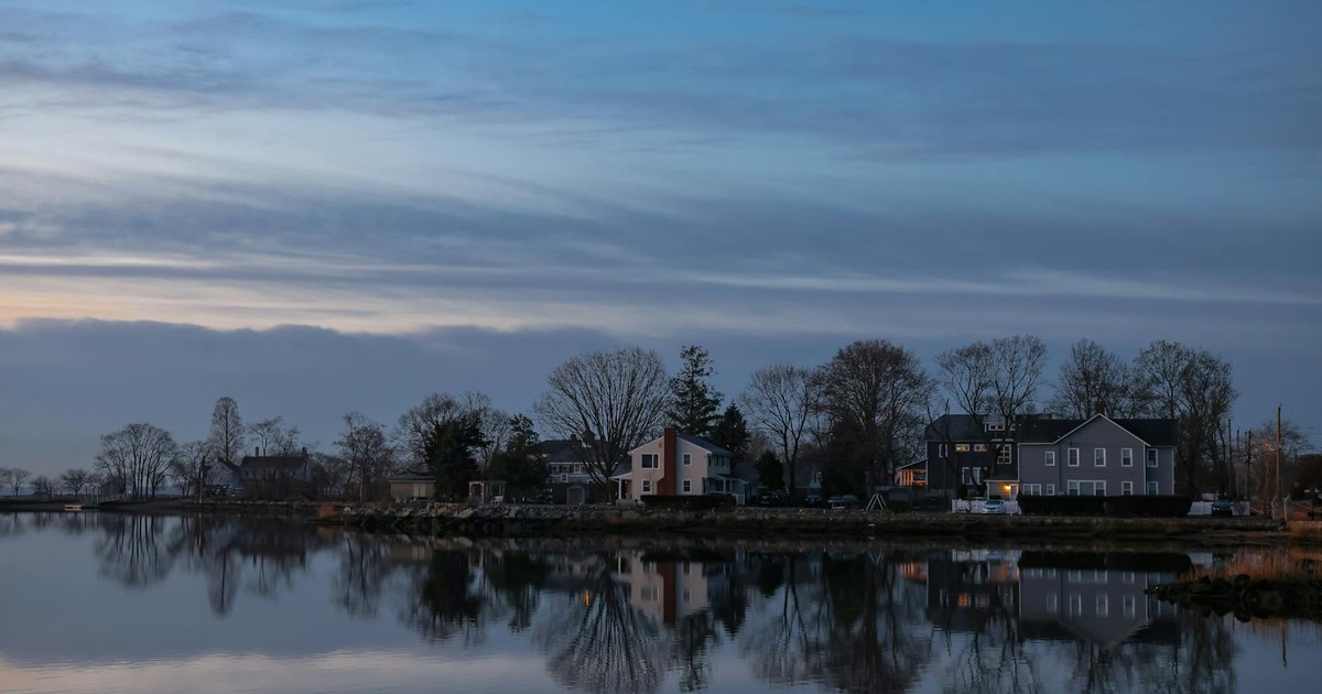 Peaceful evening view of houses reflecting on water in Stamford, Connecticut.