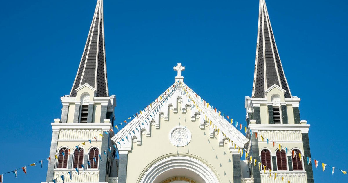 A beautiful church facade with dual spires and decorative elements against a clear blue sky.