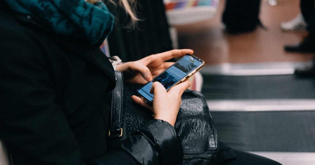 A woman uses her smartphone while commuting on public transportation.