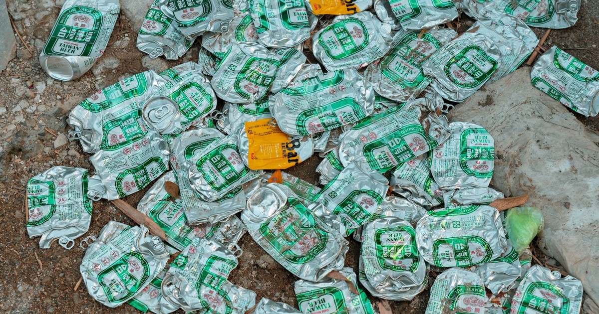 A high angle view of crushed Taiwan Beer cans scattered on the ground.