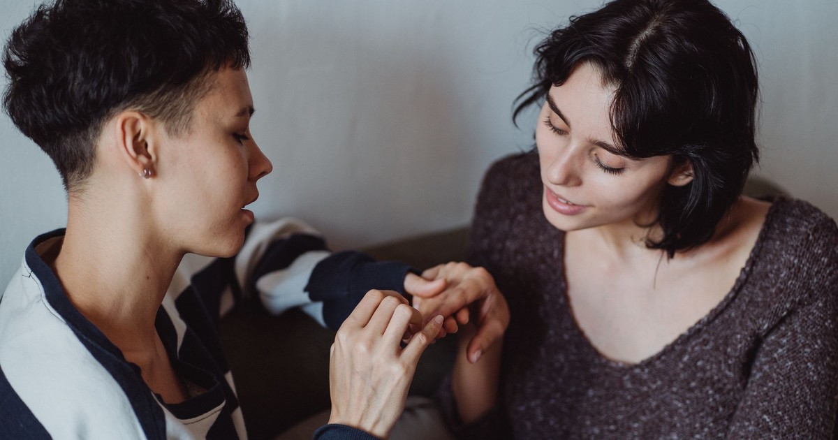 Two women sharing a tender moment while holding hands, conveying love and intimacy.