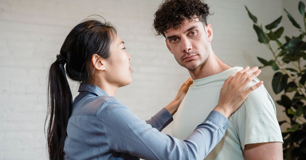Man and woman engaging in a serious discussion indoors, expressing emotions.