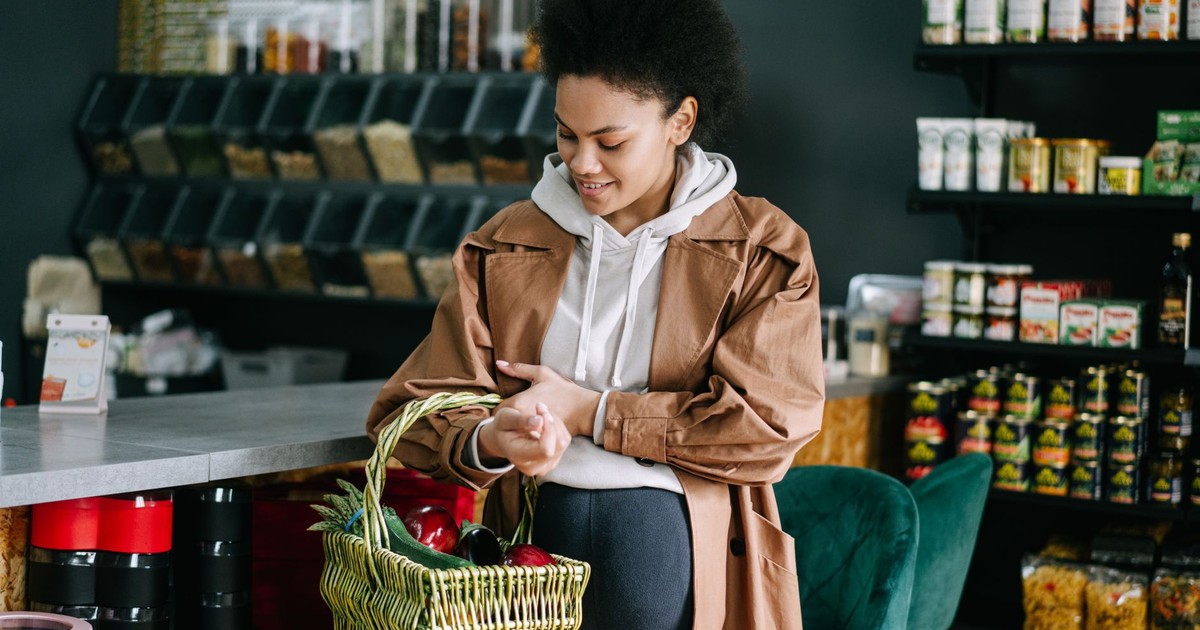 A pregnant woman shops for fresh vegetables at an organic grocery store.