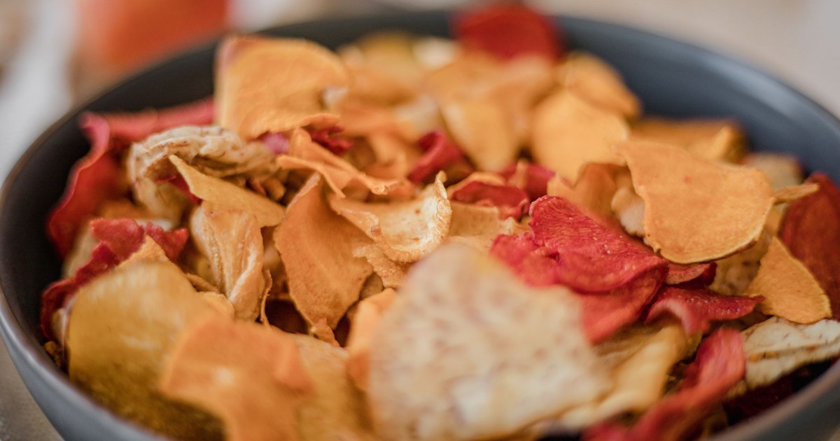 A vibrant assortment of vegetable chips in a black bowl, perfect for snack lovers.