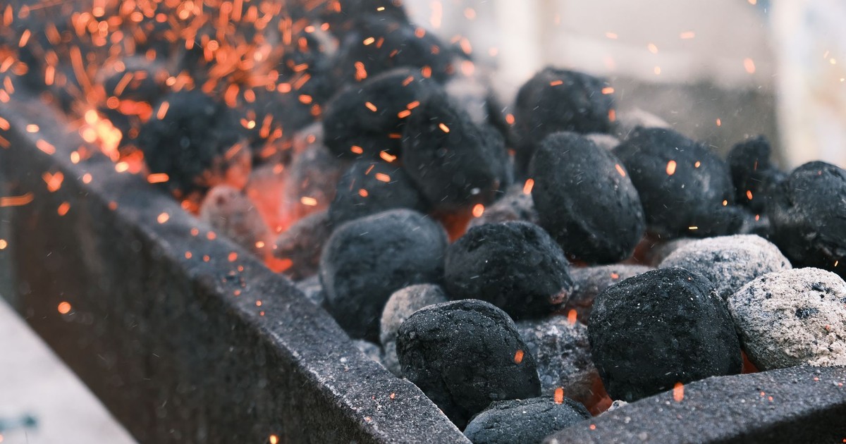 Charcoal briquettes glowing with flames and sparks. Perfect for BBQ themes.