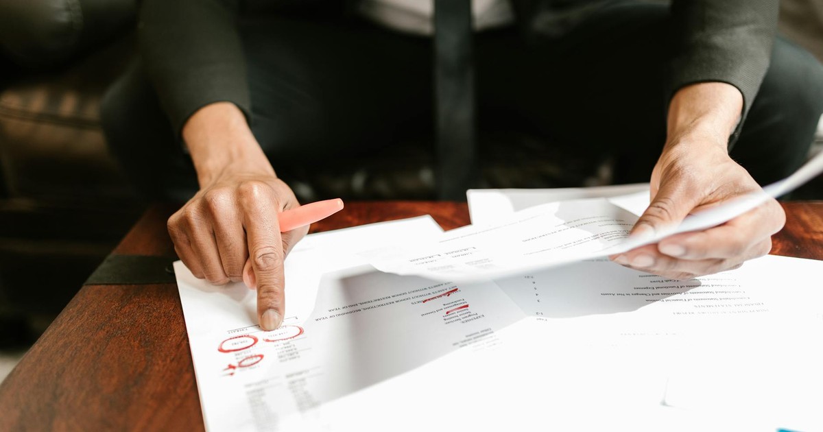 A businessman analyzing financial documents with important data and figures on a desk, ideal for business analytics and accounting themes.