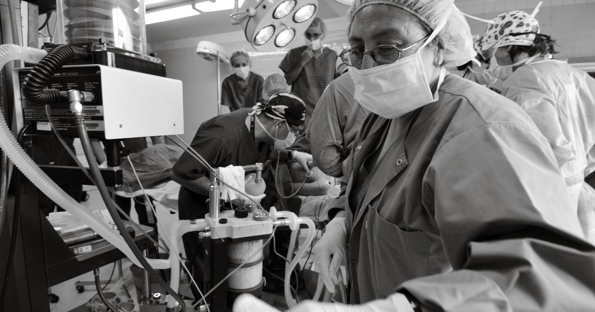 Healthcare professionals performing surgery in a busy operating room.