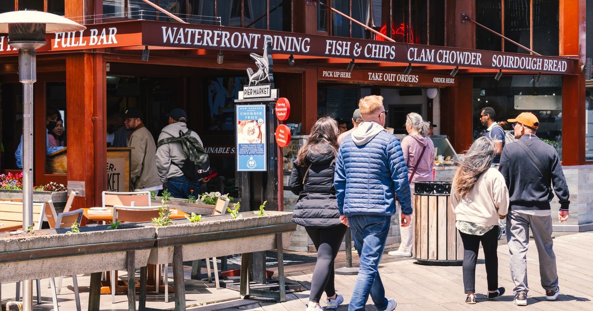 Lively waterfront dining area in San Francisco, featuring people enjoying a sunny day and popular food spots.