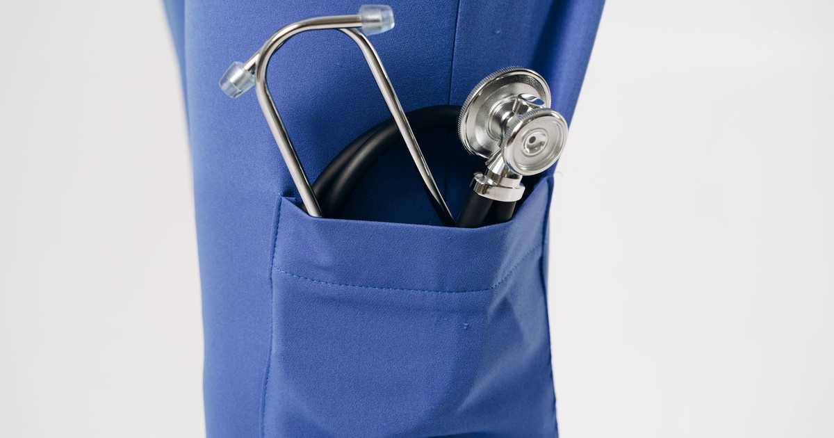 Closeup of a stethoscope in a blue pocket, representing healthcare professionalism.