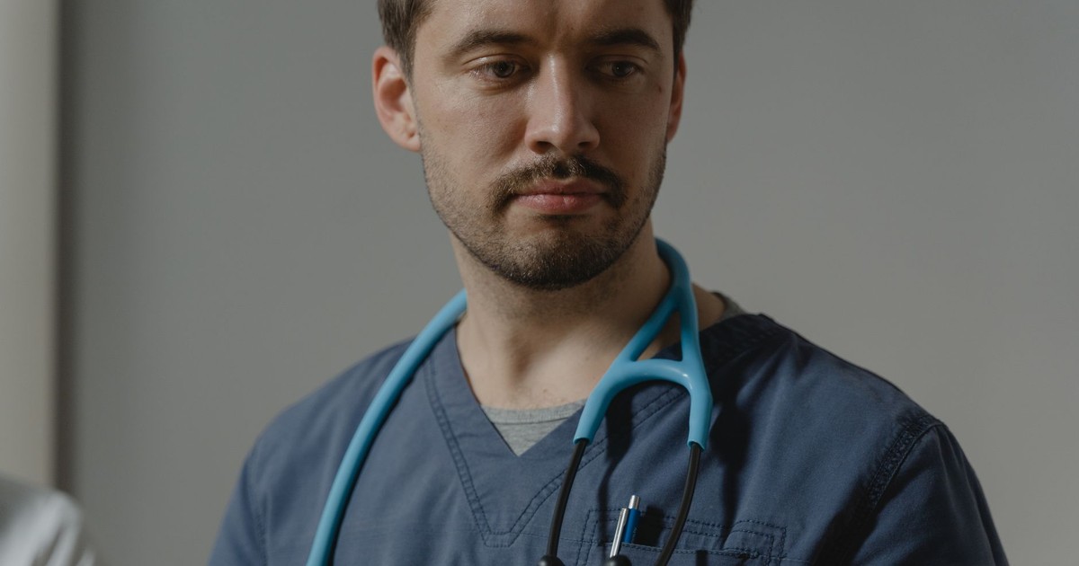 Close-up of a male healthcare worker with stethoscope in a clinical setting.