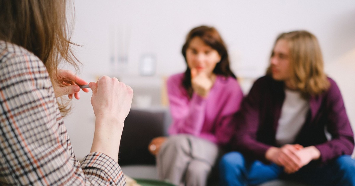 A couple in therapy, guided by a professional therapist in a calm setting.