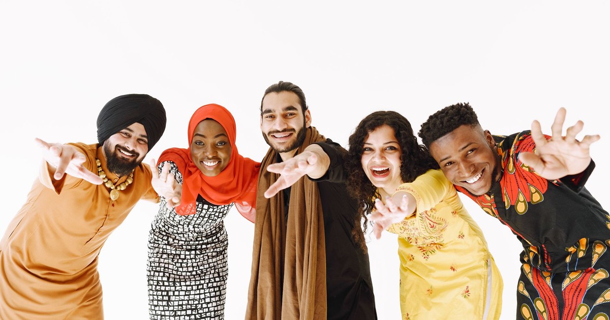 Diverse group of five friends smiling and celebrating together on a white background.