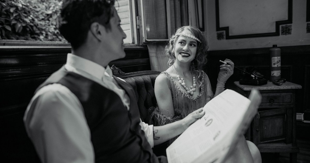 Elegant 1920s couple enjoying a moment in a Buenos Aires cafe, exuding vintage charm and romance.