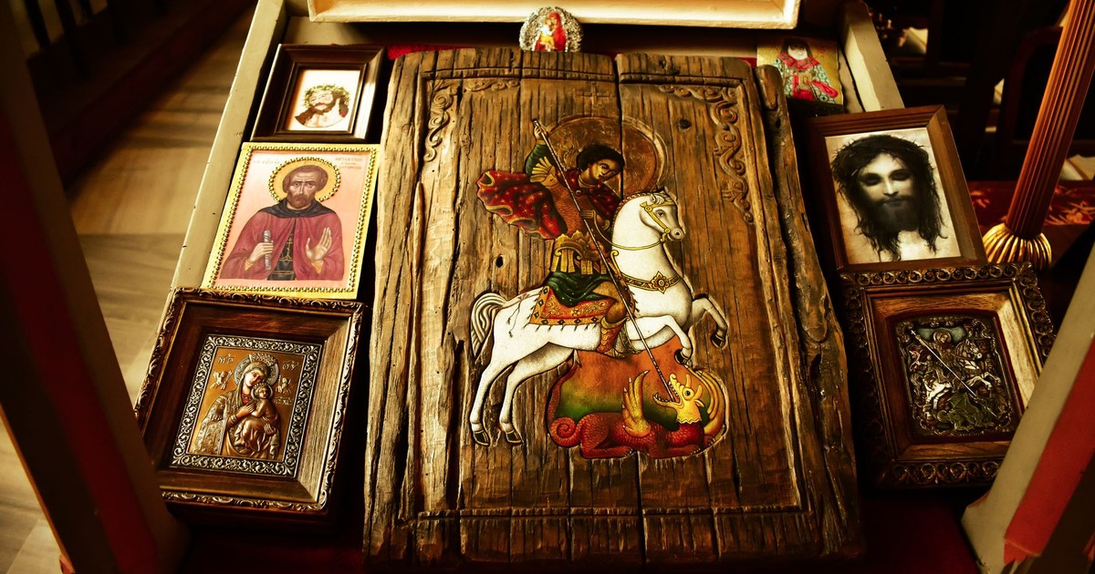 A collection of religious wood carvings and paintings displayed indoors.