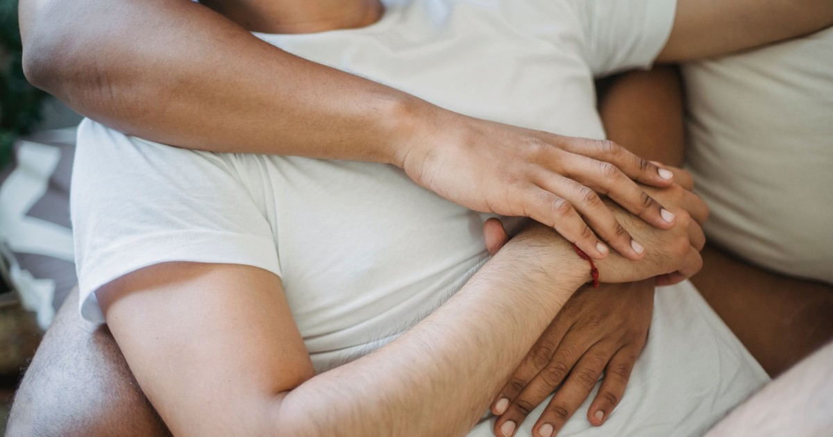 A close-up of two adults embracing, expressing love and connection at home.