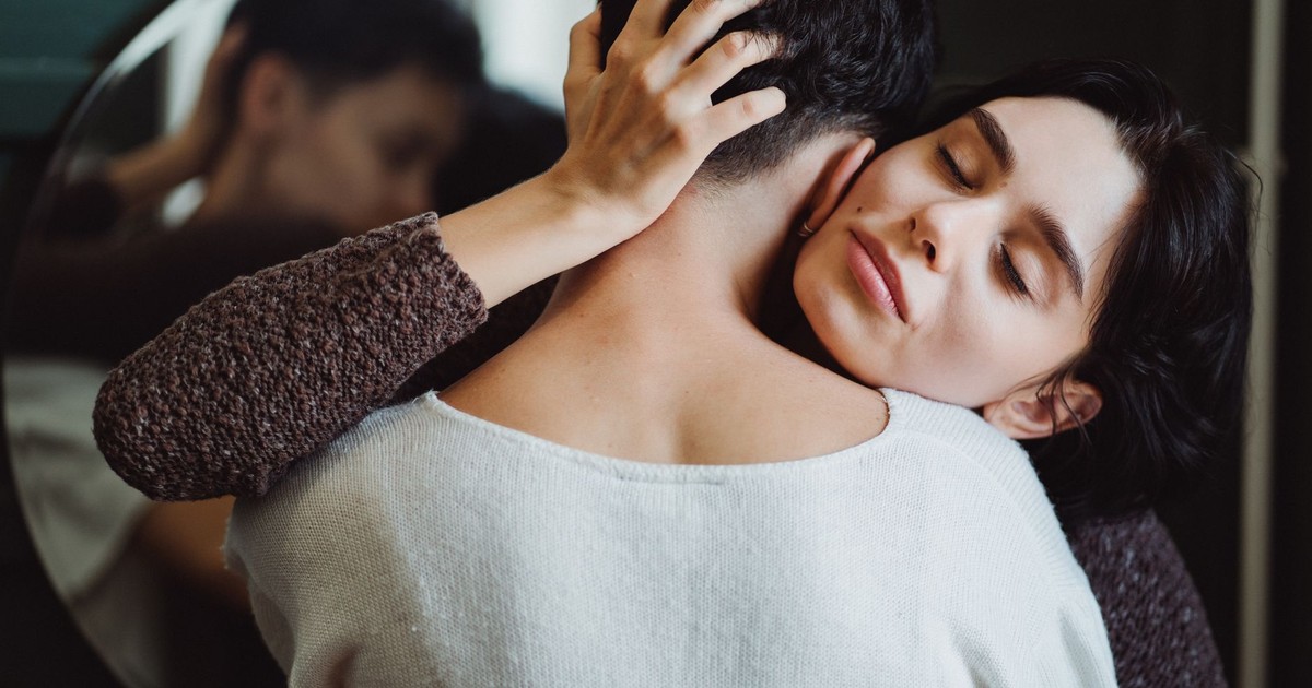 Tender embrace between two women sharing a moment of affection and connection indoors.