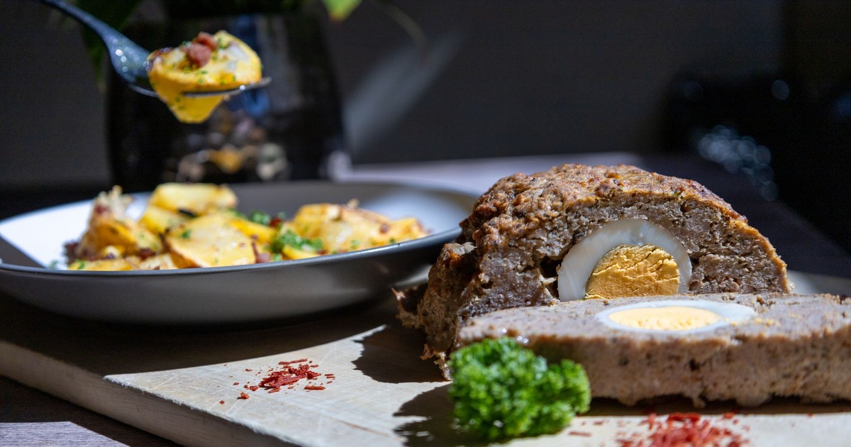Tasty meatloaf with egg centerpiece served with potatoes. Perfect for a hearty meal.