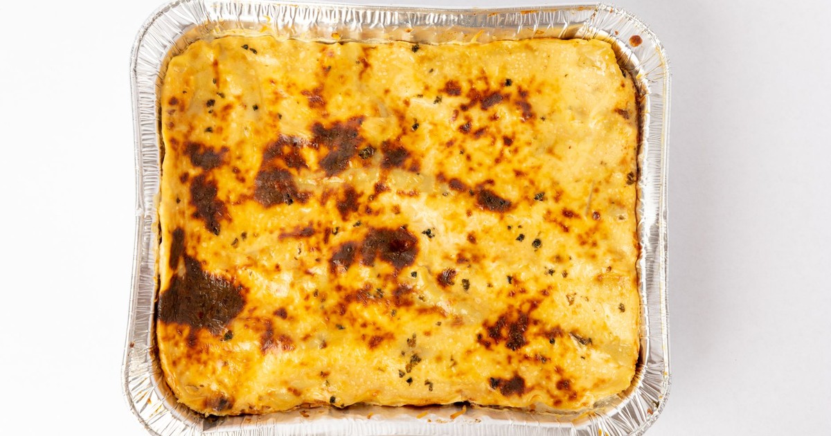 A freshly baked lasagna with golden cheese crust captured from above in a foil tray.