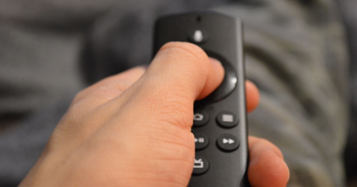 Close-up of a person's hand holding a TV remote control in Berlin, Germany.