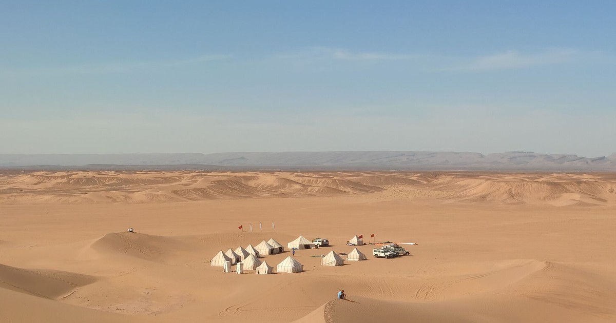 Explore the serene beauty of an isolated desert camp amidst the Sahara dunes in Morocco.