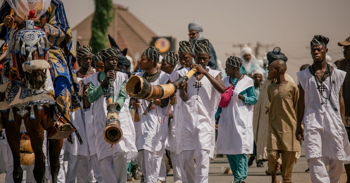 Festive parade in Nigeria featuring traditional attire and musical performances.