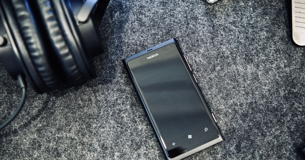 Close-up of Nokia smartphone and headphones on grey surface, conveying modern technology concept.