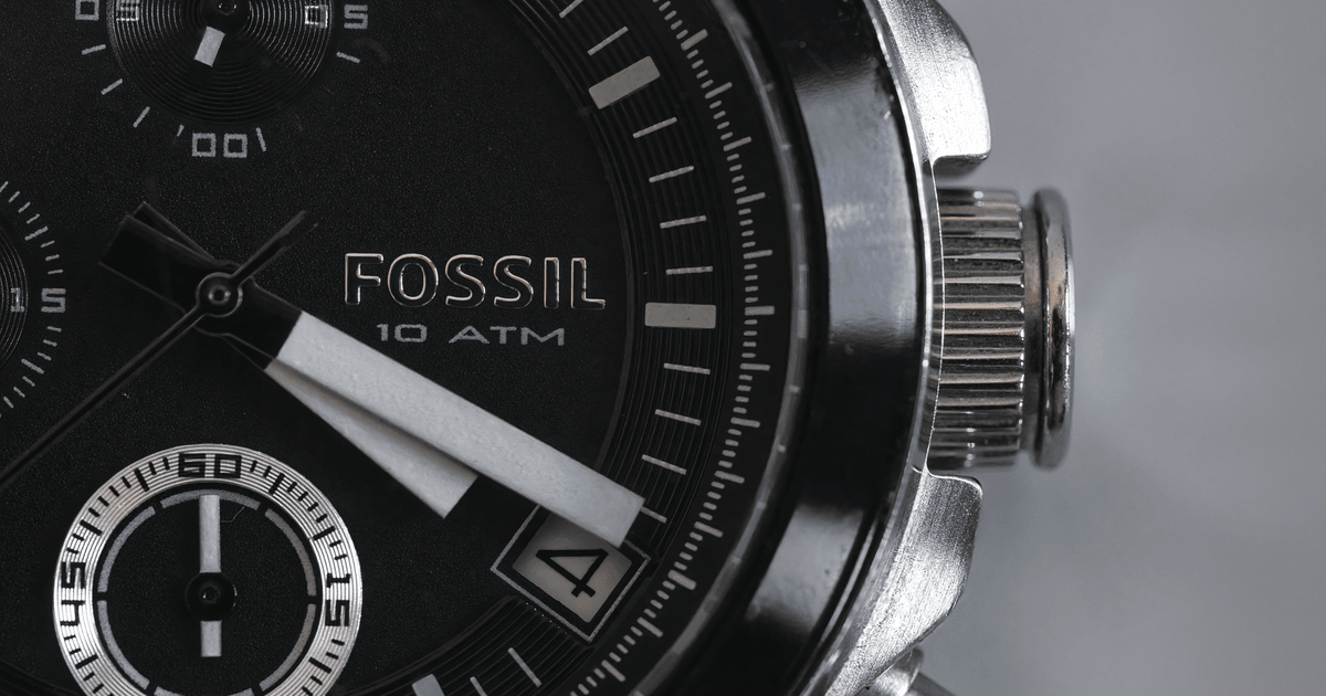 Detailed close-up of a Fossil wristwatch face with visible chronograph and date features.
