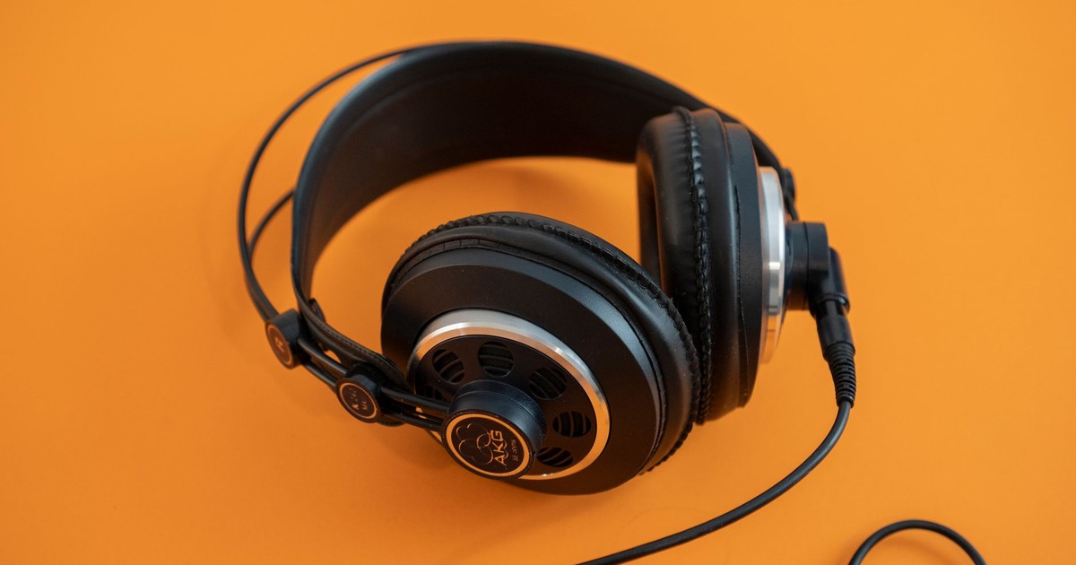 Studio shot of black headphones on a vibrant orange background highlighting electronic accessory design.