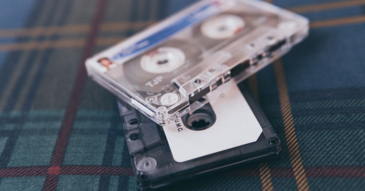 Close-up of retro cassette tapes on plaid fabric, evoking nostalgia and vintage vibes.