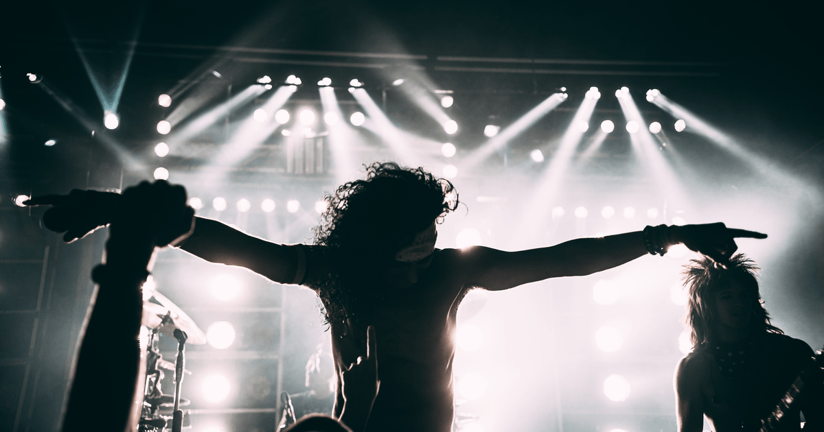 Energetic rock band performance with striking stage lights and silhouettes.