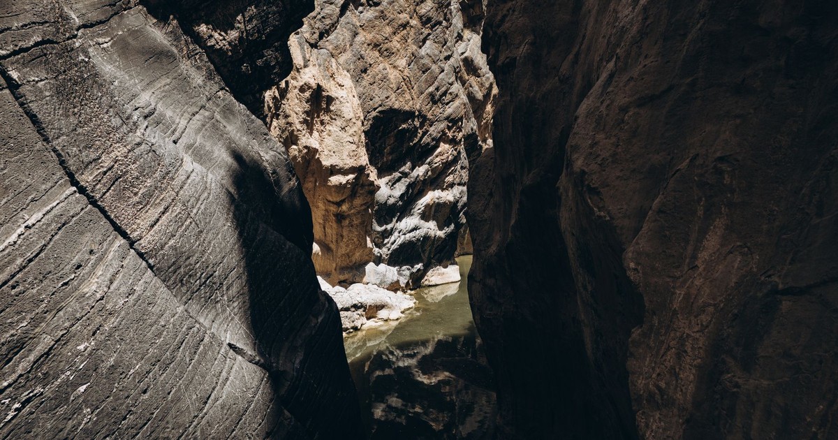 Stunning aerial view of a deep canyon with water, showcasing natural beauty in Oman.