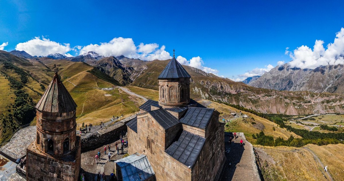 Stunning aerial view of Gergeti Trinity Church against the backdrop of the majestic Caucasus Mountains.