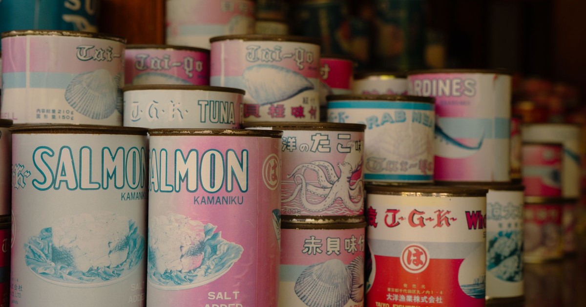 Vintage cans of Japanese seafood including salmon and tuna, displayed in a Tokyo shop.