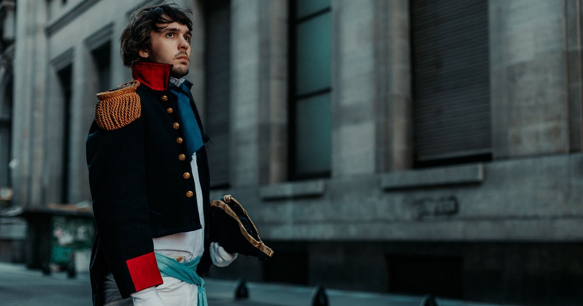 Man in historical costume walking down a Buenos Aires street, capturing classic military style.