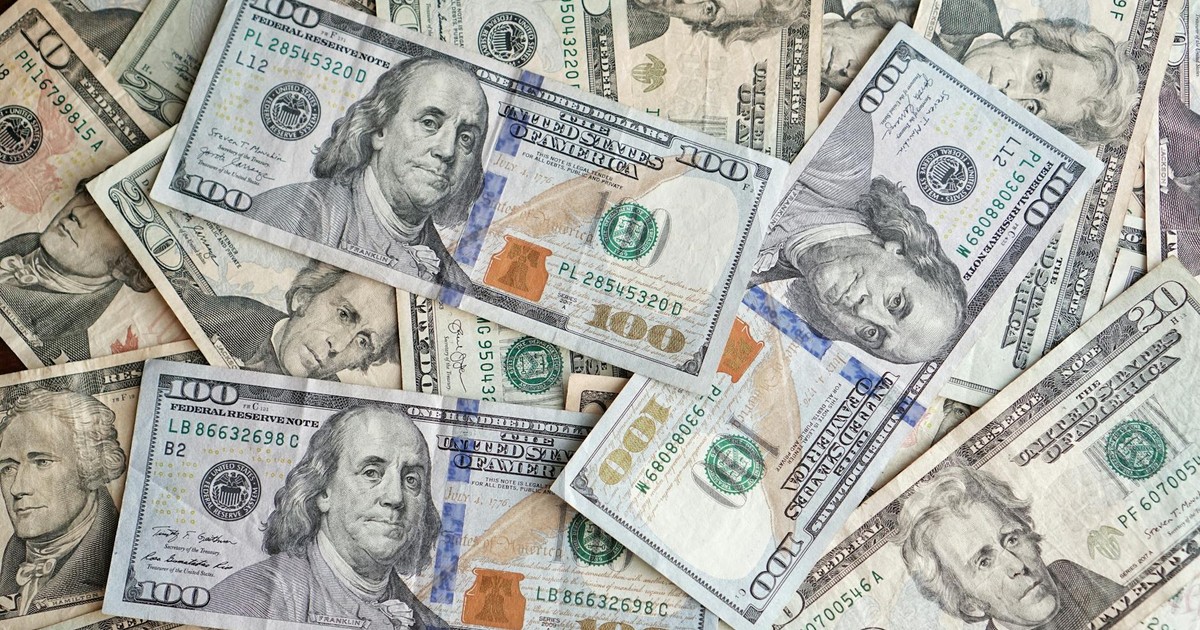 A close-up view of scattered US dollar bills showcasing various denominations and presidents.