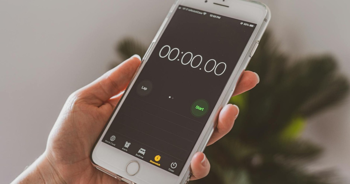 Smartphone held in hand displaying a stopwatch timer app.