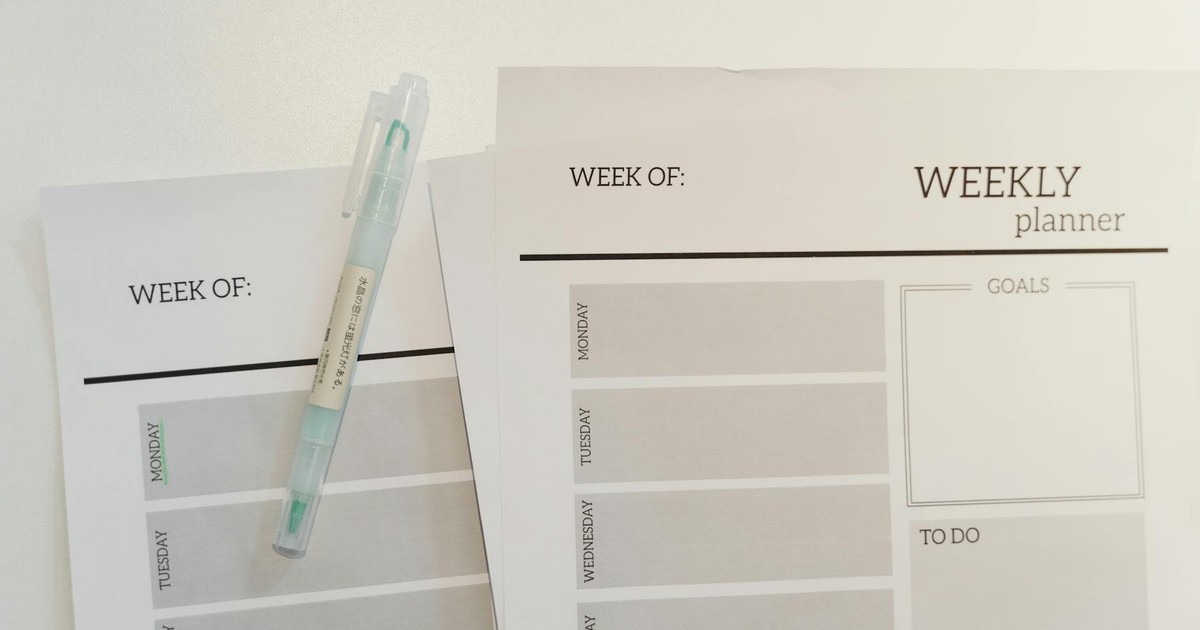 Organized weekly planner sheets with a pen for efficient scheduling and goal setting.