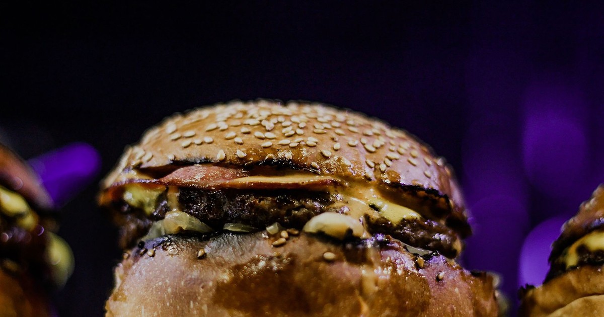 Mouth-watering close-up of a delicious cheeseburger with a sesame seed bun, captured in vibrant detail.