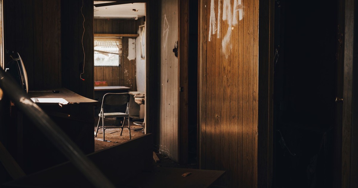Explore the eerie and intriguing atmosphere of an abandoned house interior with shadows and scattered furniture.