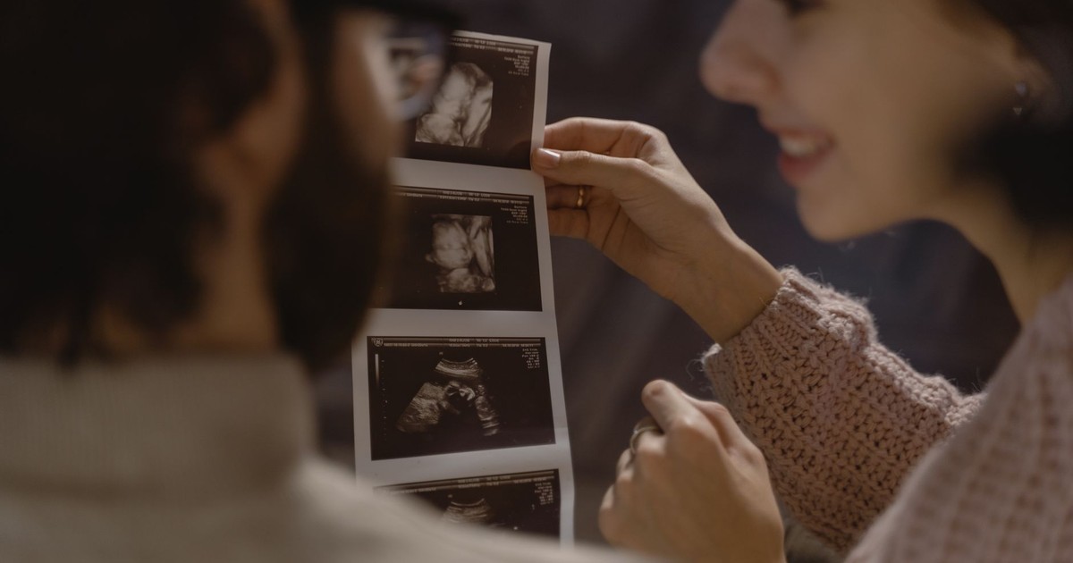 Couple excitedly viewing ultrasound images, celebrating pregnancy and parenthood.