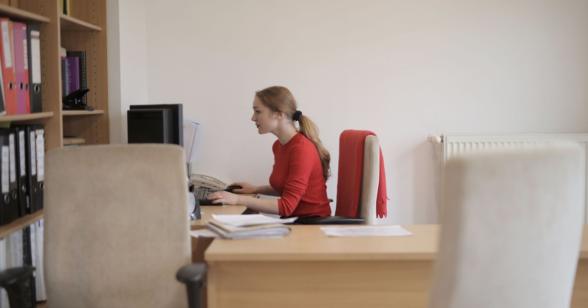 Side view of a woman concentrating on computer work in a contemporary office setting.