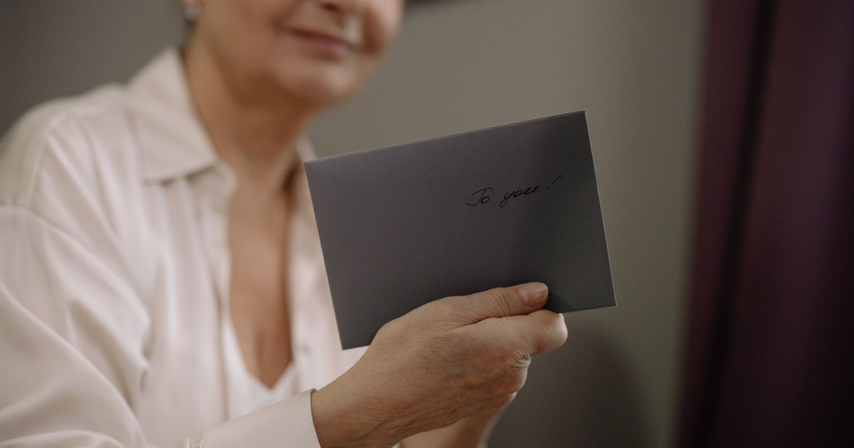 An elderly woman holds a heartfelt letter. The envelope reads 'To you' in elegant handwriting.