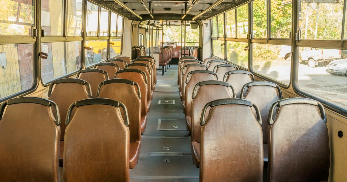 Interior view of an empty vintage bus in Wrocław, Poland, showcasing rows of brown seats.