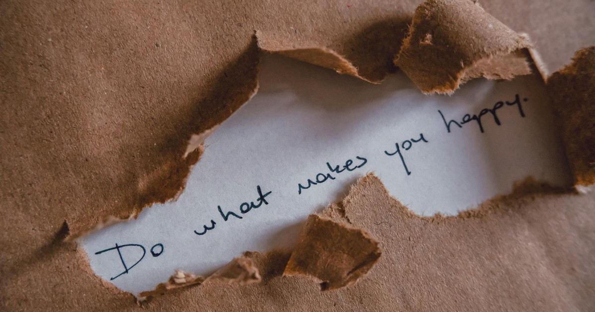 Brown paper revealing message 'Do what makes you happy.'