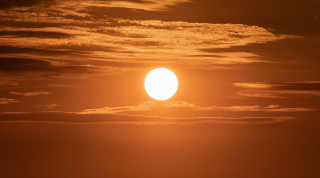 Captivating image of the sun setting over a vibrant golden sky filled with clouds, creating a dramatic scene