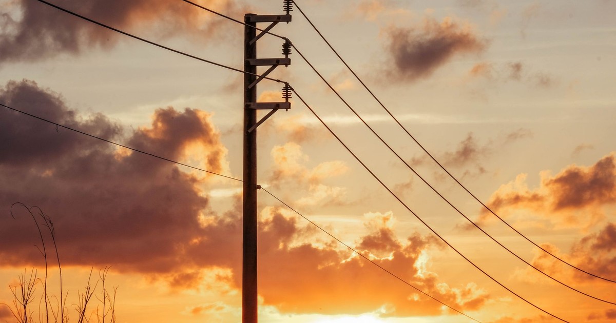 A beautiful sunset in Bình Thuận, Vietnam with silhouetted power lines against a vibrant sky.