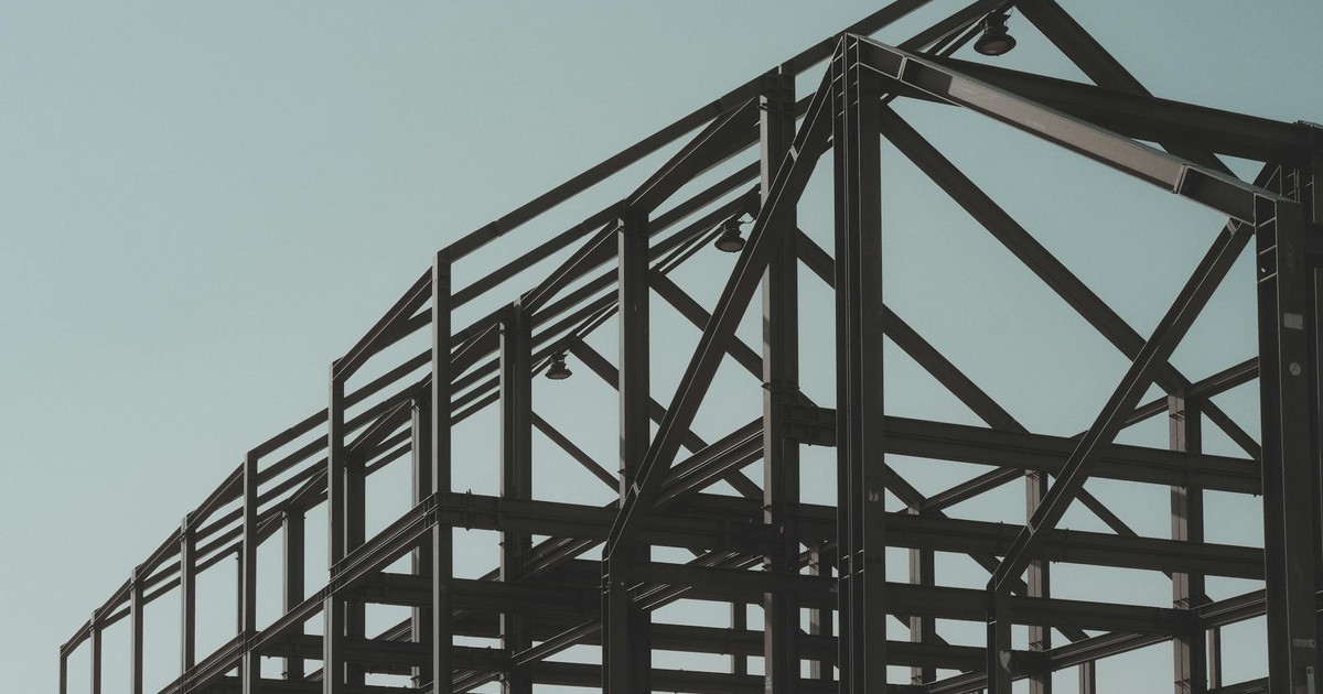 Modern steel framework structure under clear sky, showcasing architectural design.