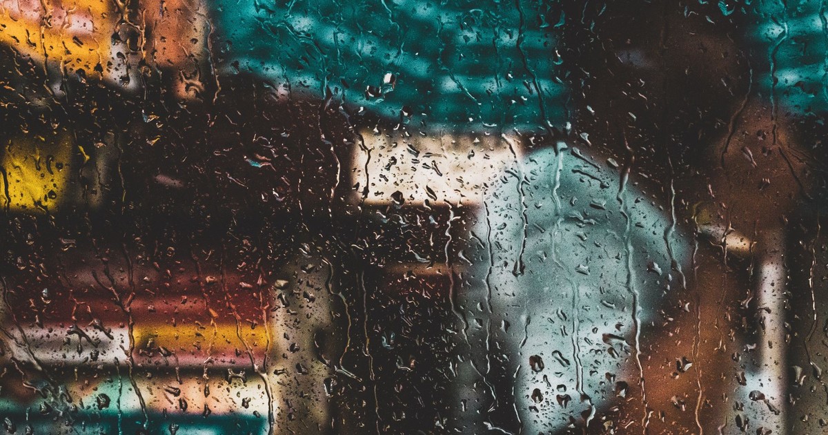Blurred view through a rain-soaked window capturing the vibrant essence of Kolkata's streets.