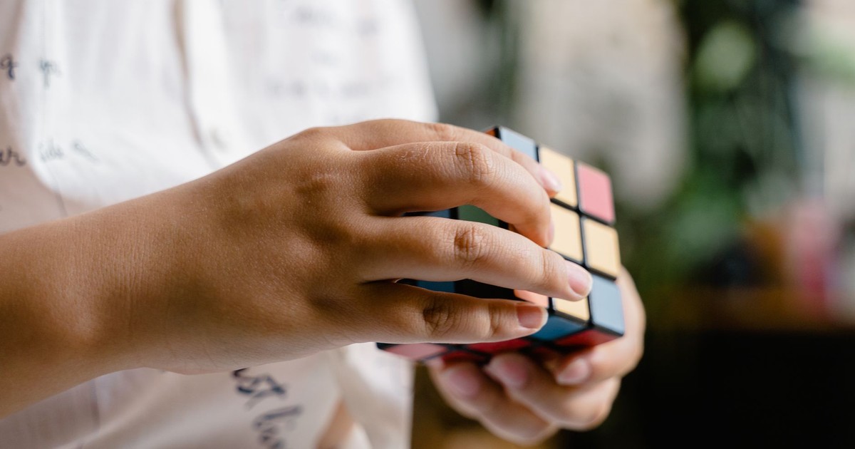 Hands manipulating a Rubik's Cube, showcasing concentration and skill.