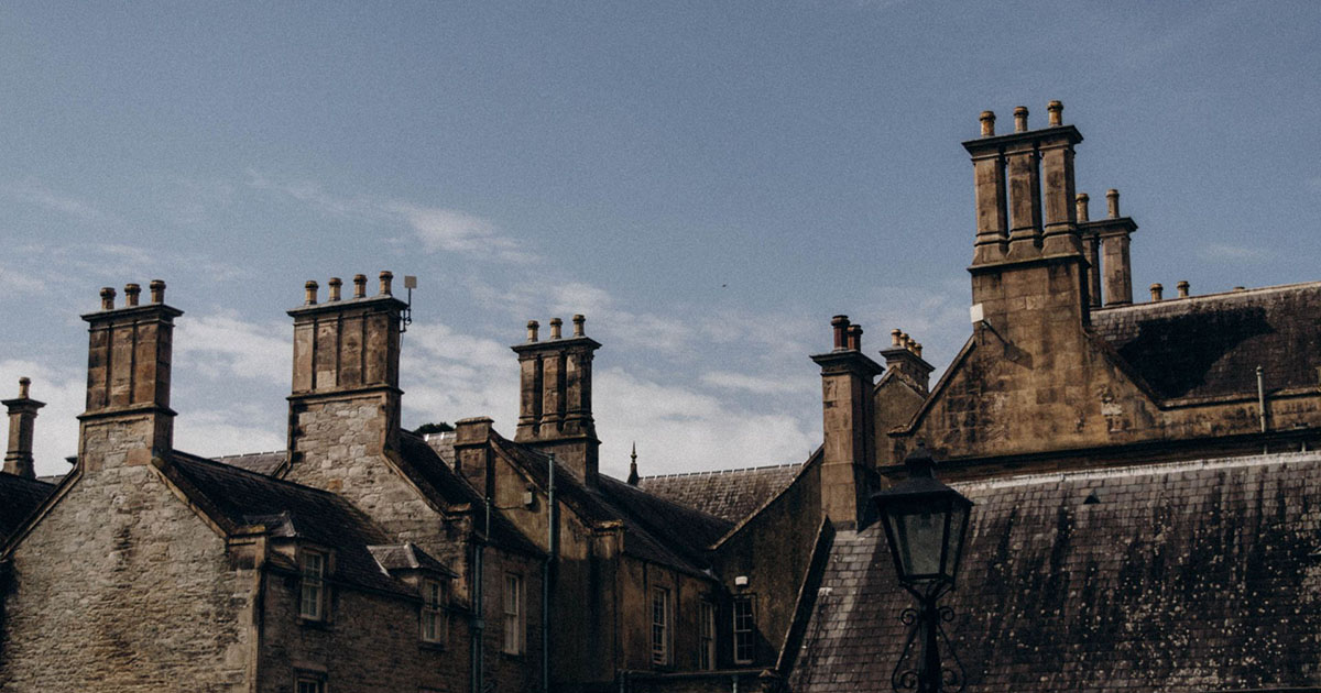A captivating view of historic Gothic brick buildings with tall chimneys under a clear sky